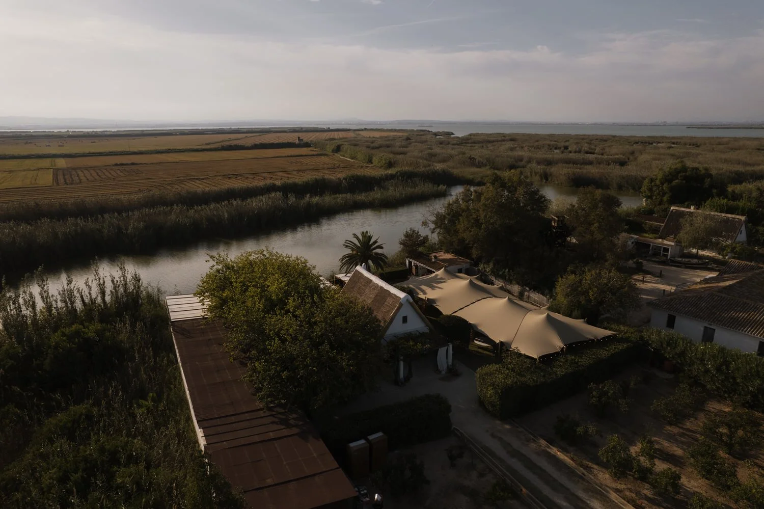 Aerial view of La Barraca del Palmar surrounded by rice fields and waterways in Albufera Natural Park
