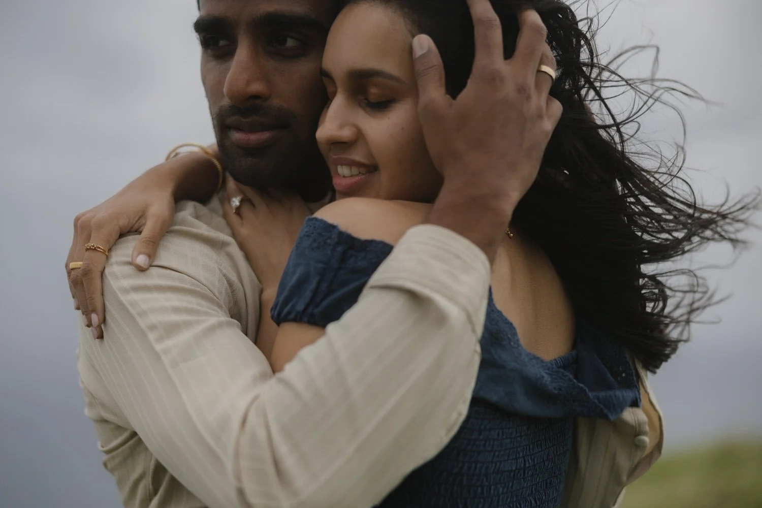 Intimate close-up of Manoj and Nimisha embracing in the wind during their engagement session in São Miguel Azores