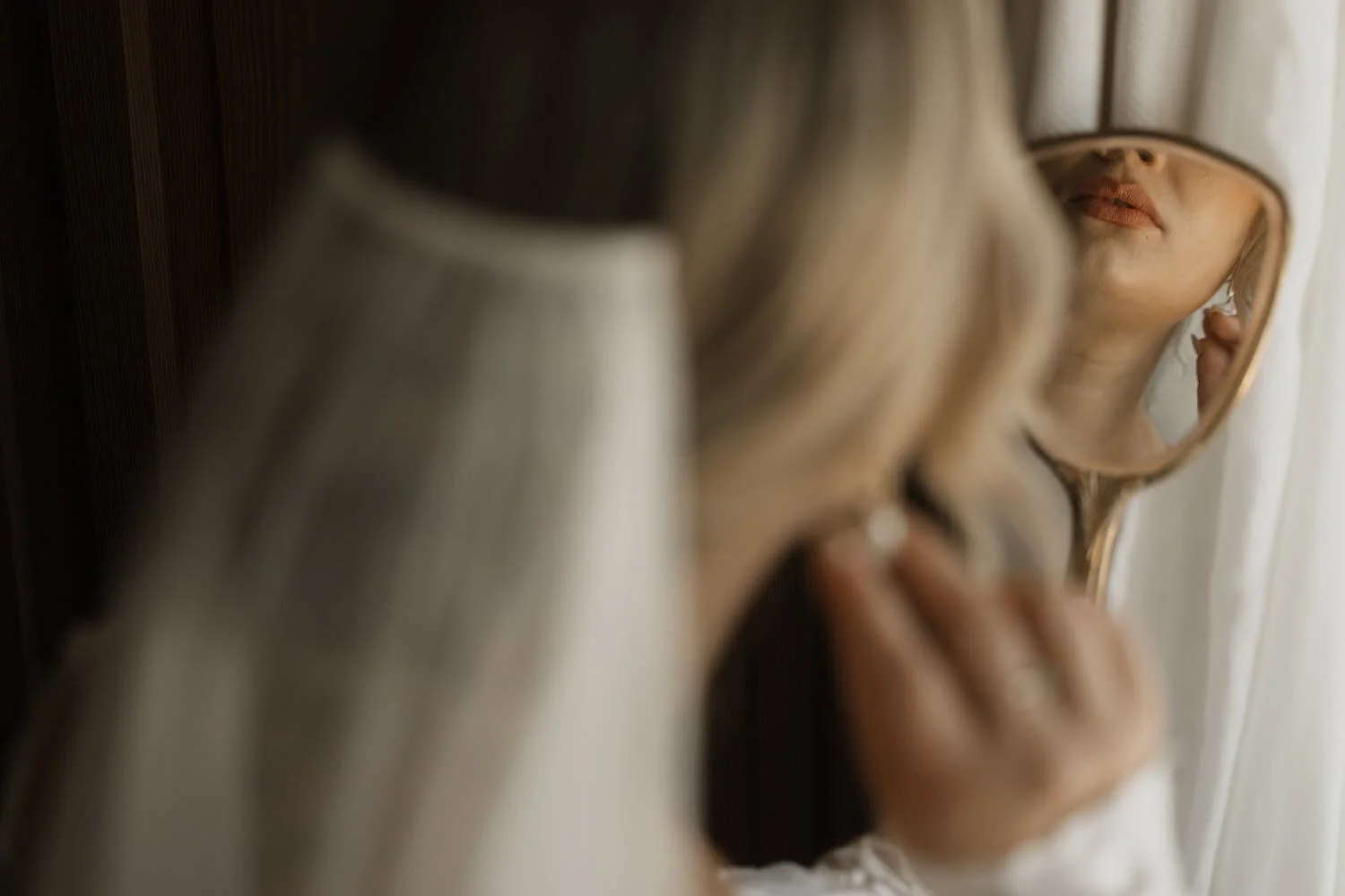 Bride putting on her wedding earrings in front of the mirror at a Mallorca finca