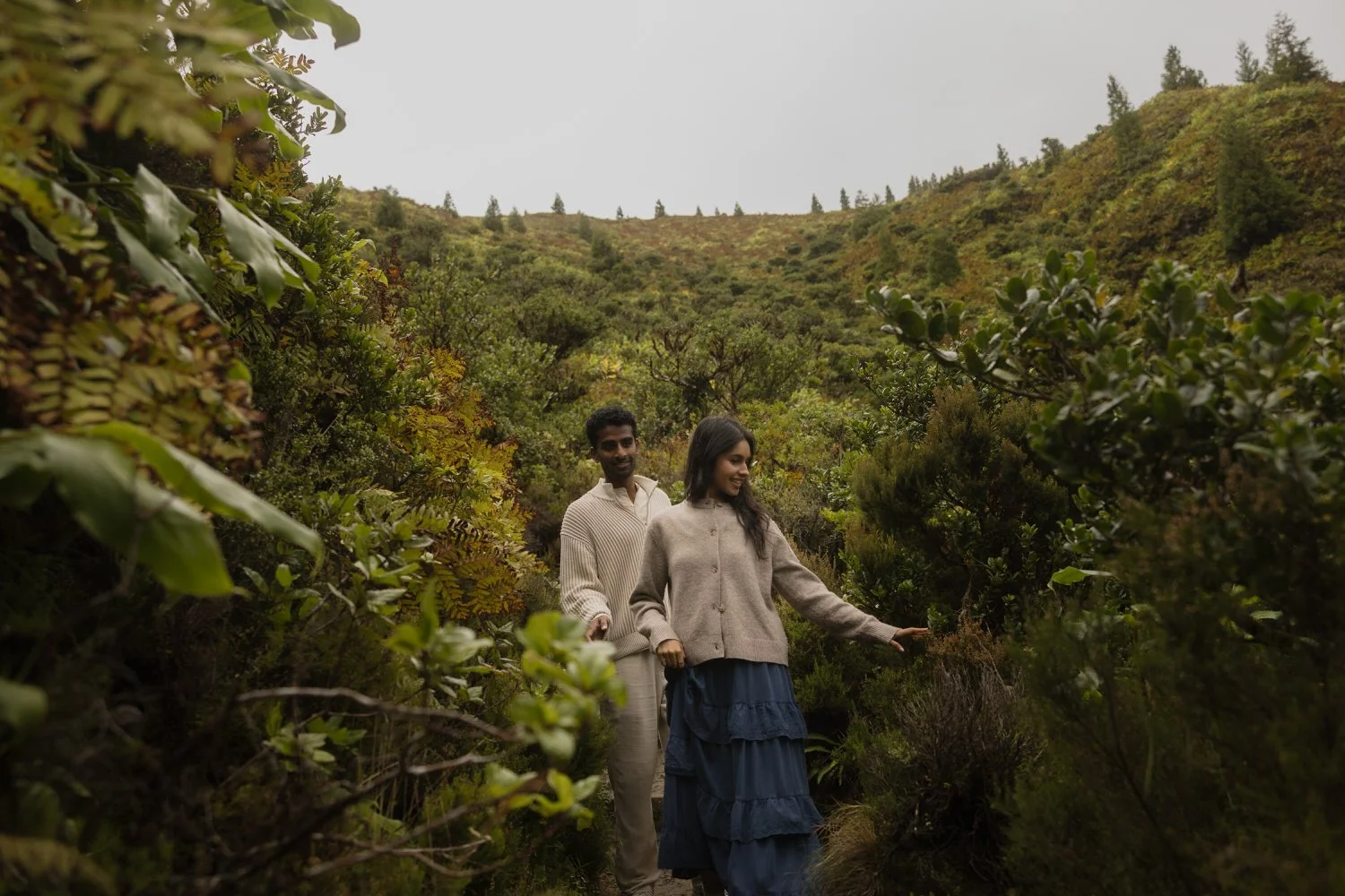 Couple walking through lush volcanic landscape in São Miguel Azores during engagement session