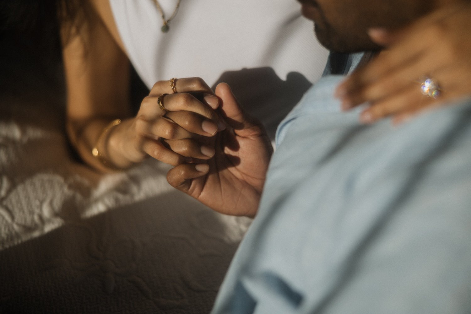 Close-up of Manoj and Nimisha holding hands in warm light at their accommodation in São Miguel, Azores