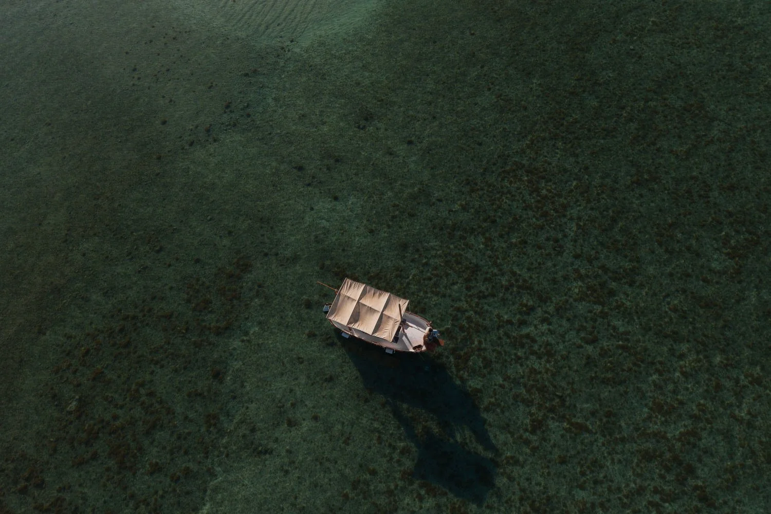 Boat anchored in the clear waters of Mallorca during a sunrise elopement.