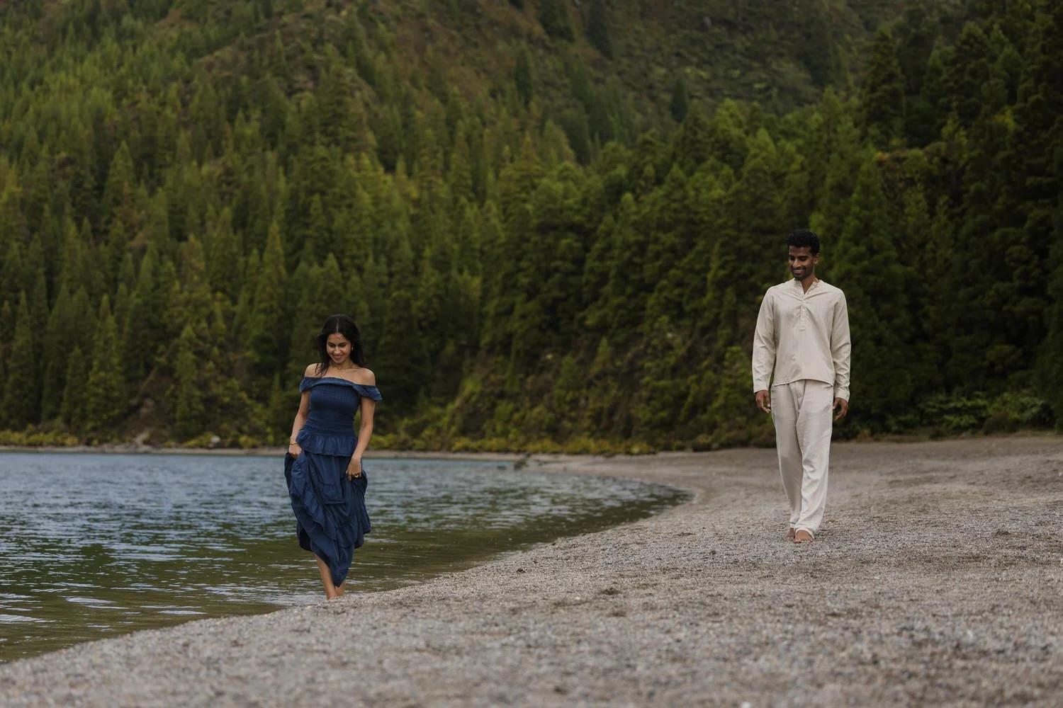 Couple walking along remote volcanic lake shore in São Miguel Azores
