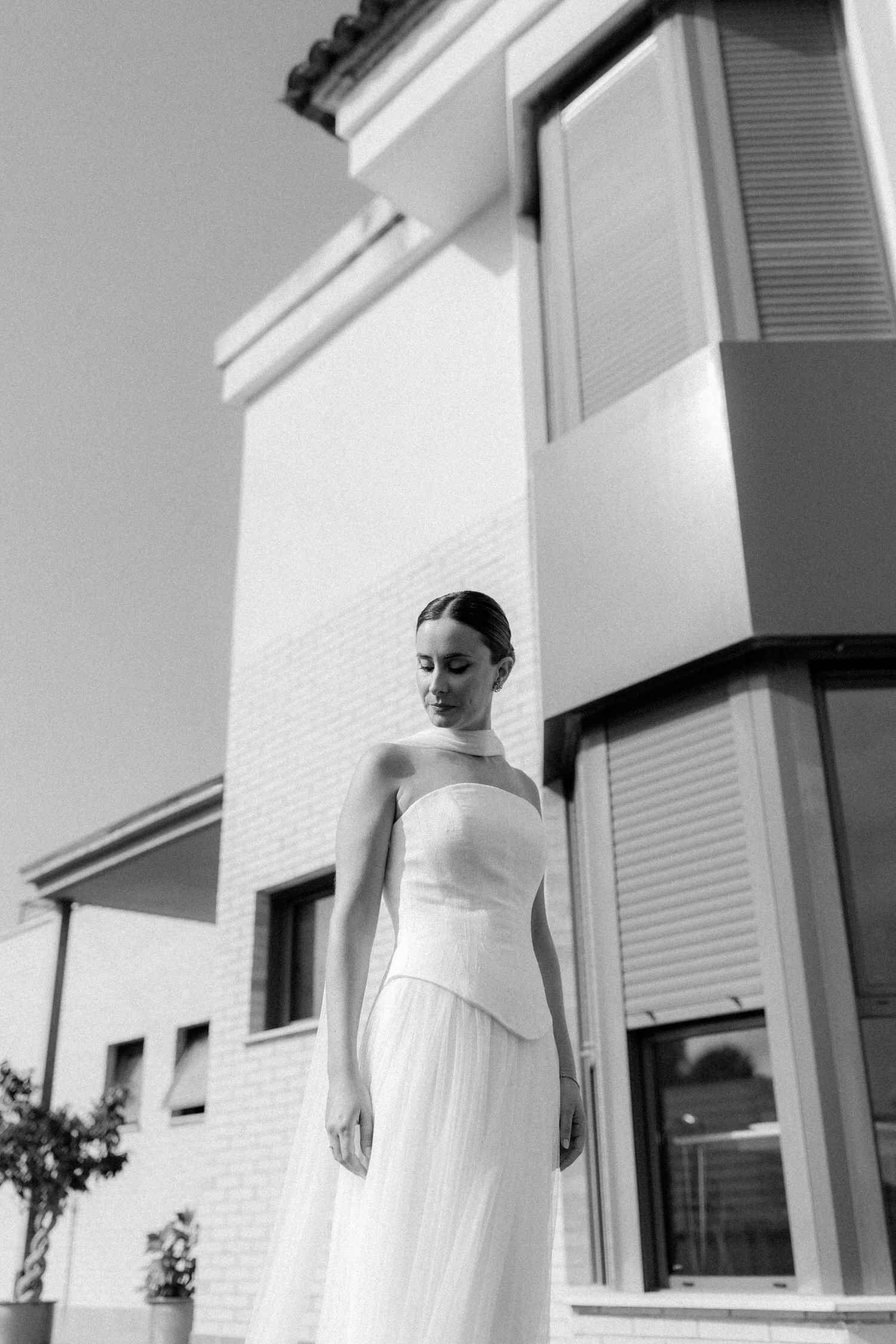 Bride wearing her wedding dress during preparations at home, photographed in natural light before the ceremony