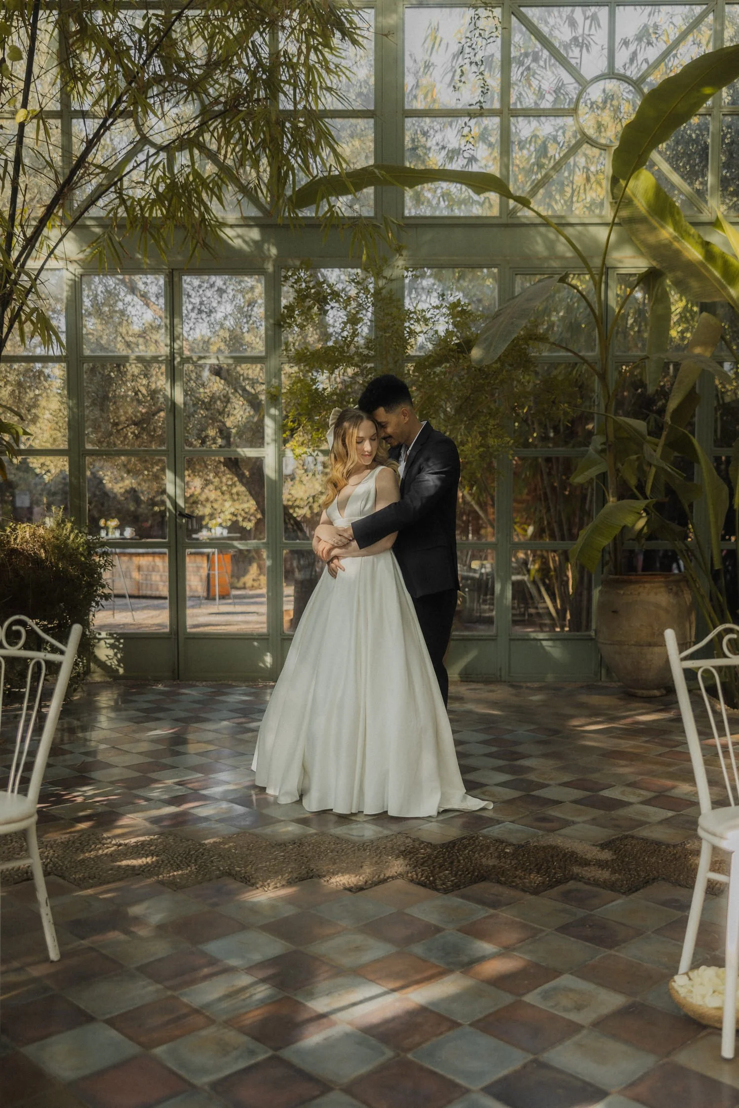 Bride and groom embracing inside the greenhouse at Beldi Country Club in Marrakech, surrounded by soft natural light and lush greenery during their destination wedding.