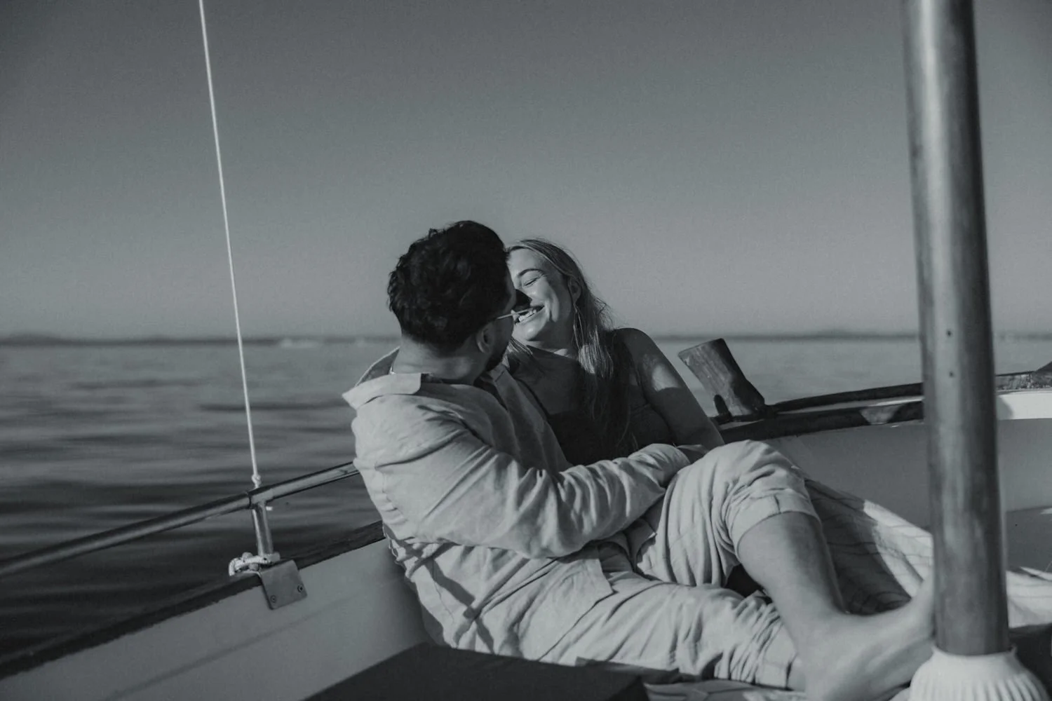 Couple laughing together during a sunrise boat trip along the coast of Mallorca.
