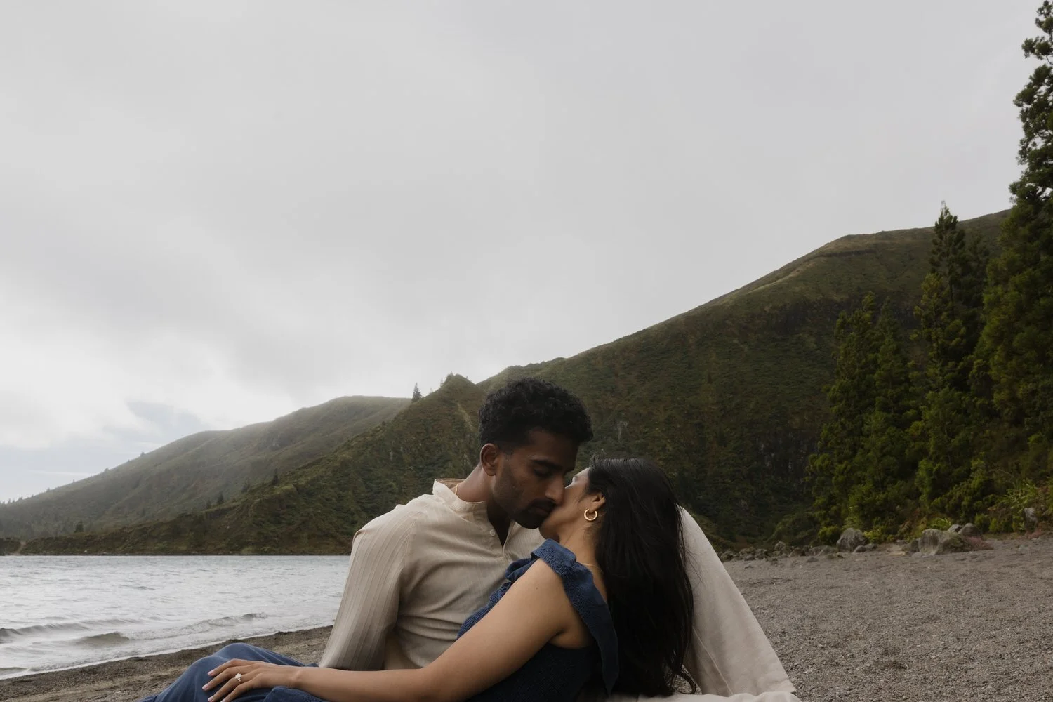 Engaged couple kissing by volcanic lake in São Miguel Azores