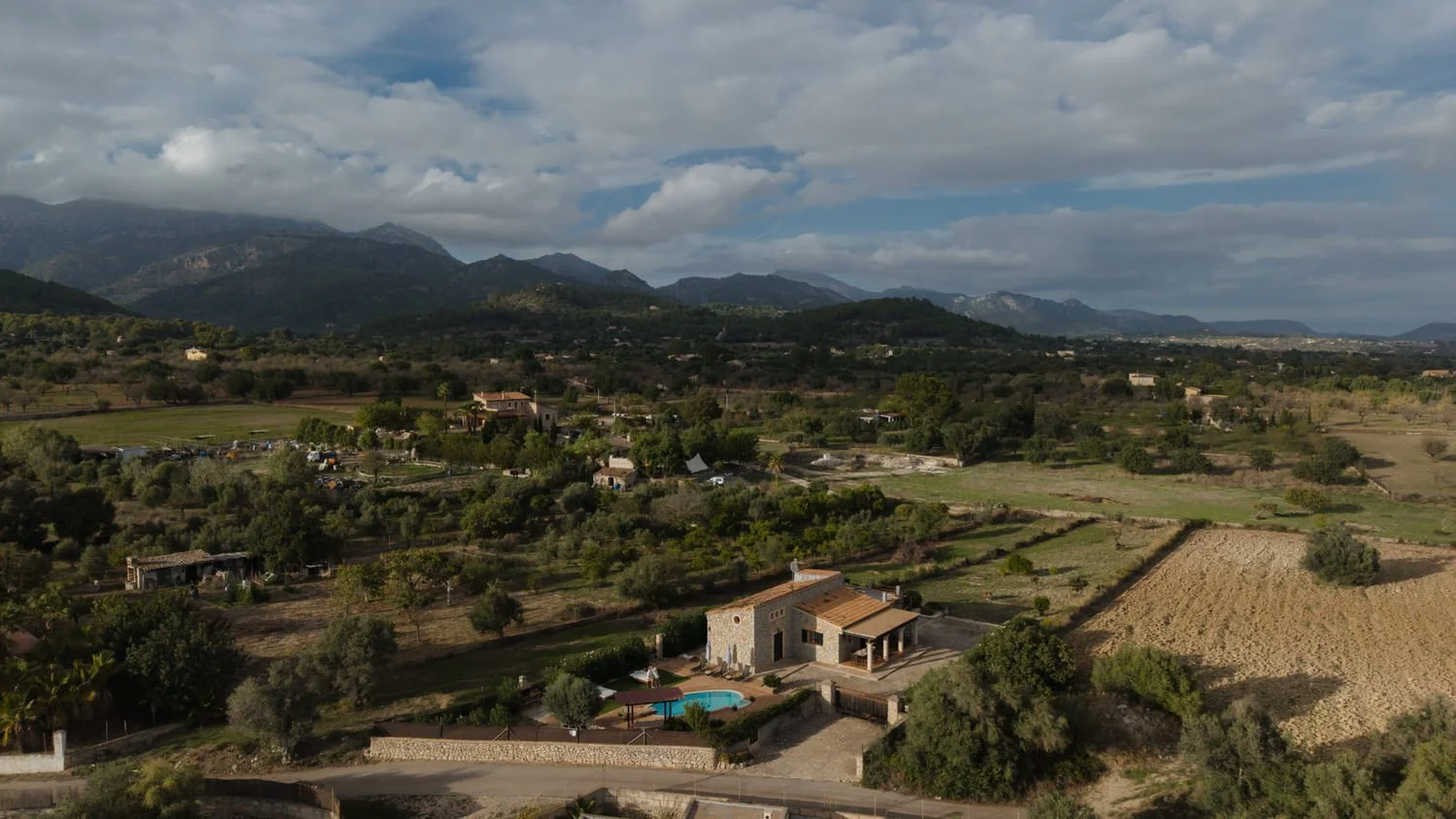 Aerial view of a rustic villa in Mallorca surrounded by mountains and countryside, location for a luxury elopement with private chef and intimate celebration
