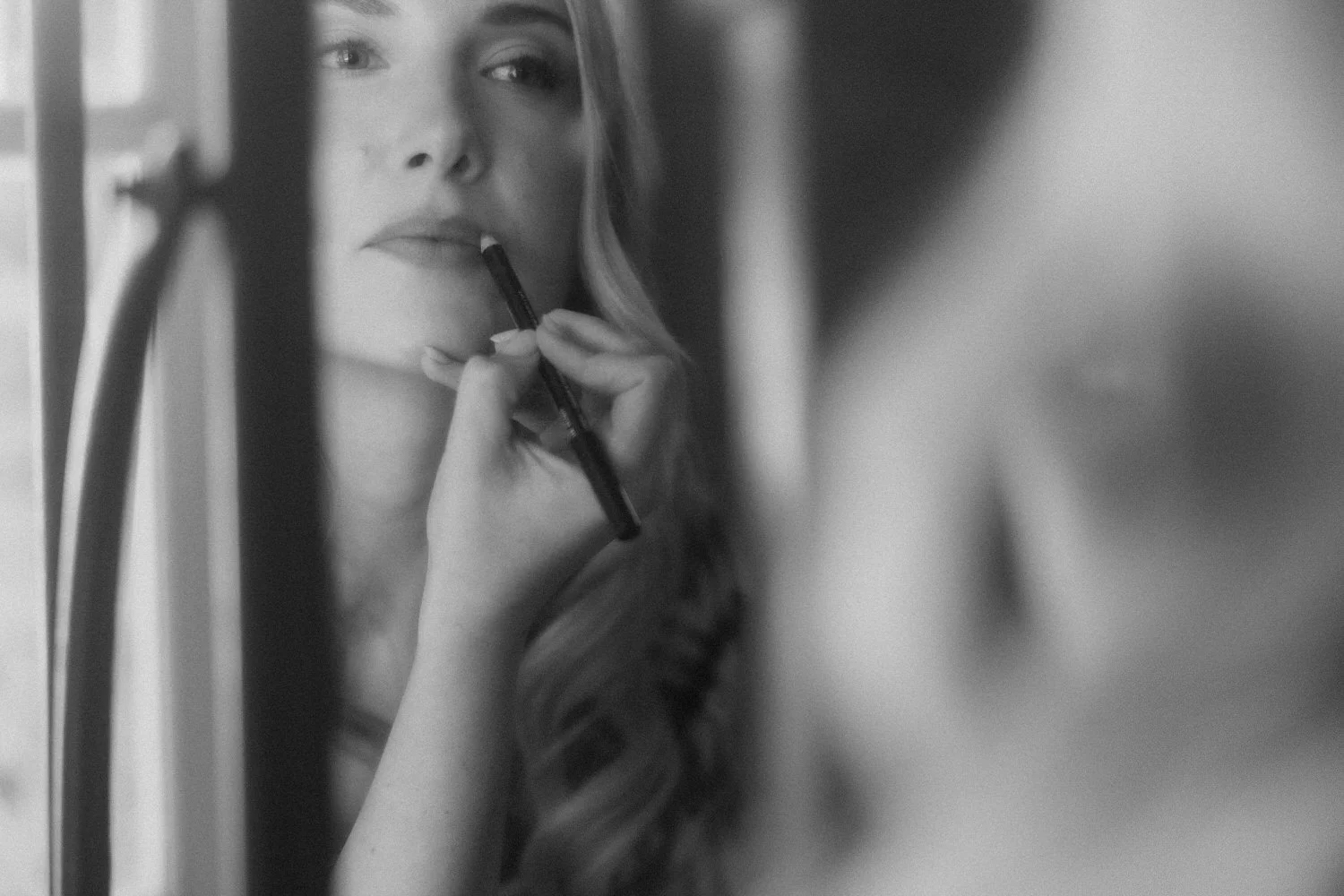 Bride applying lip liner during her Beldi Country Club wedding preparations in Marrakech, captured in a soft and intimate moment.