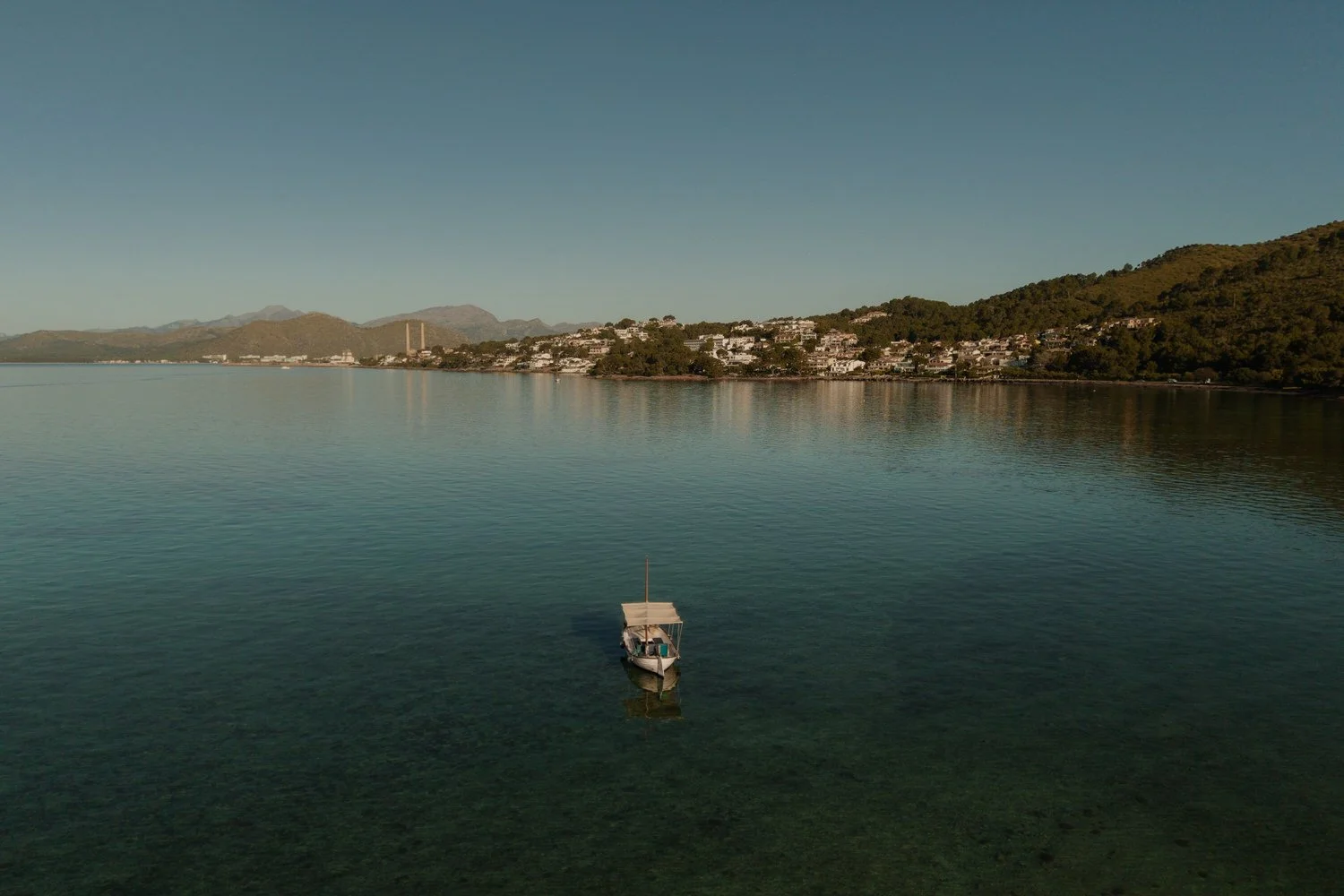 Boat anchored in the calm waters of Mallorca during a sunrise elopement.