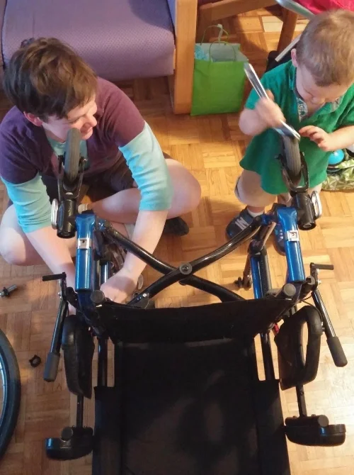 Marie and her son working on a friend's wheelchair.