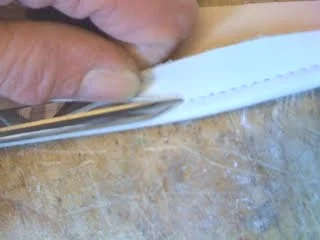 Begin by making one cut with the scissors near the stitch line.