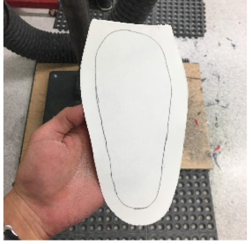 Grab your posting material, place under the device and trace around. Cut the material approximately ¾ of an inch outside of this traced line to provide enough length when folding over the apex of the device, such as the medial arch.