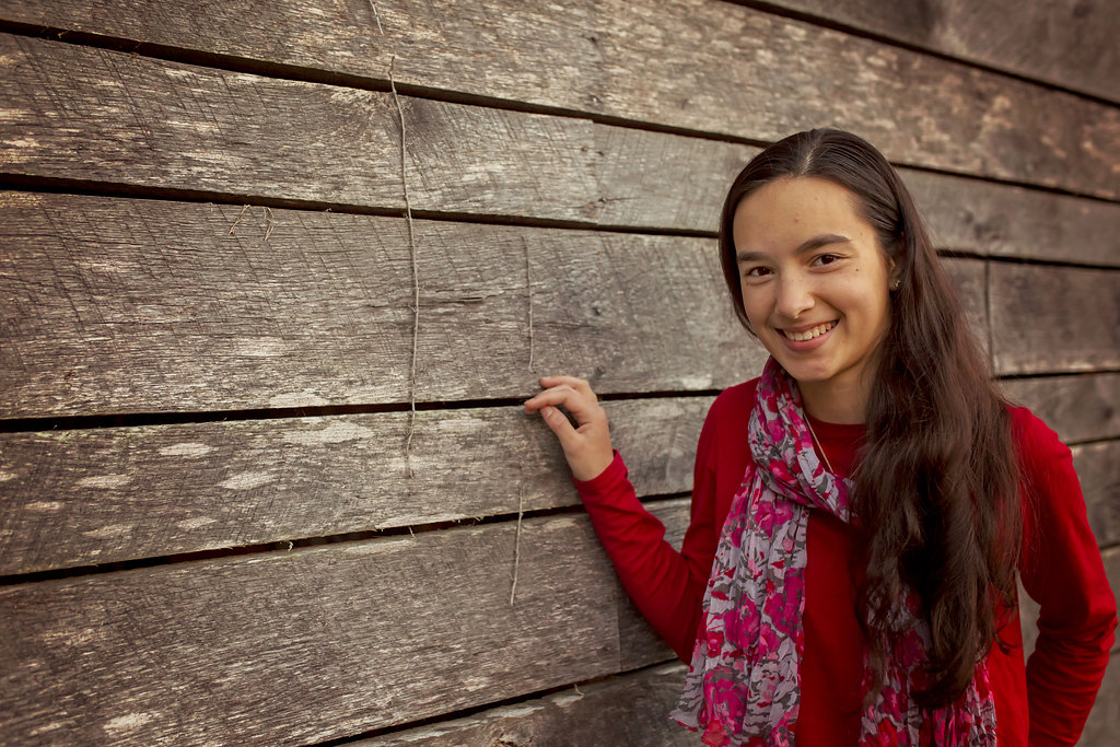  Pinehurst NC daughter stands near barn for family photos.&nbsp; 