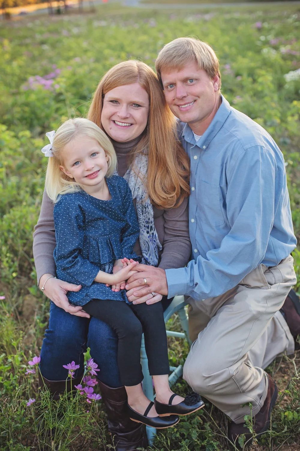 Young couple with child in flower field