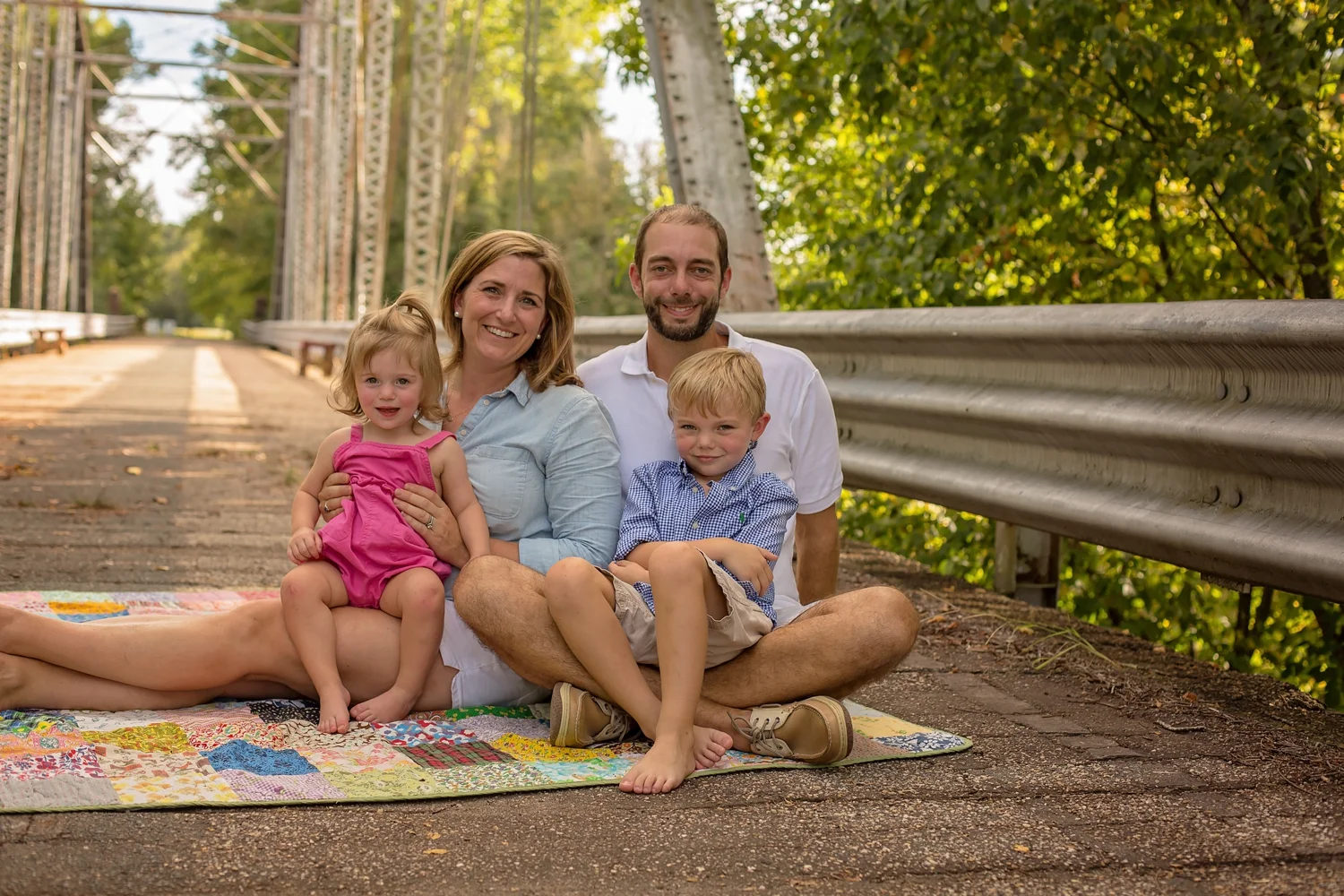 Family on quilt with toddlers