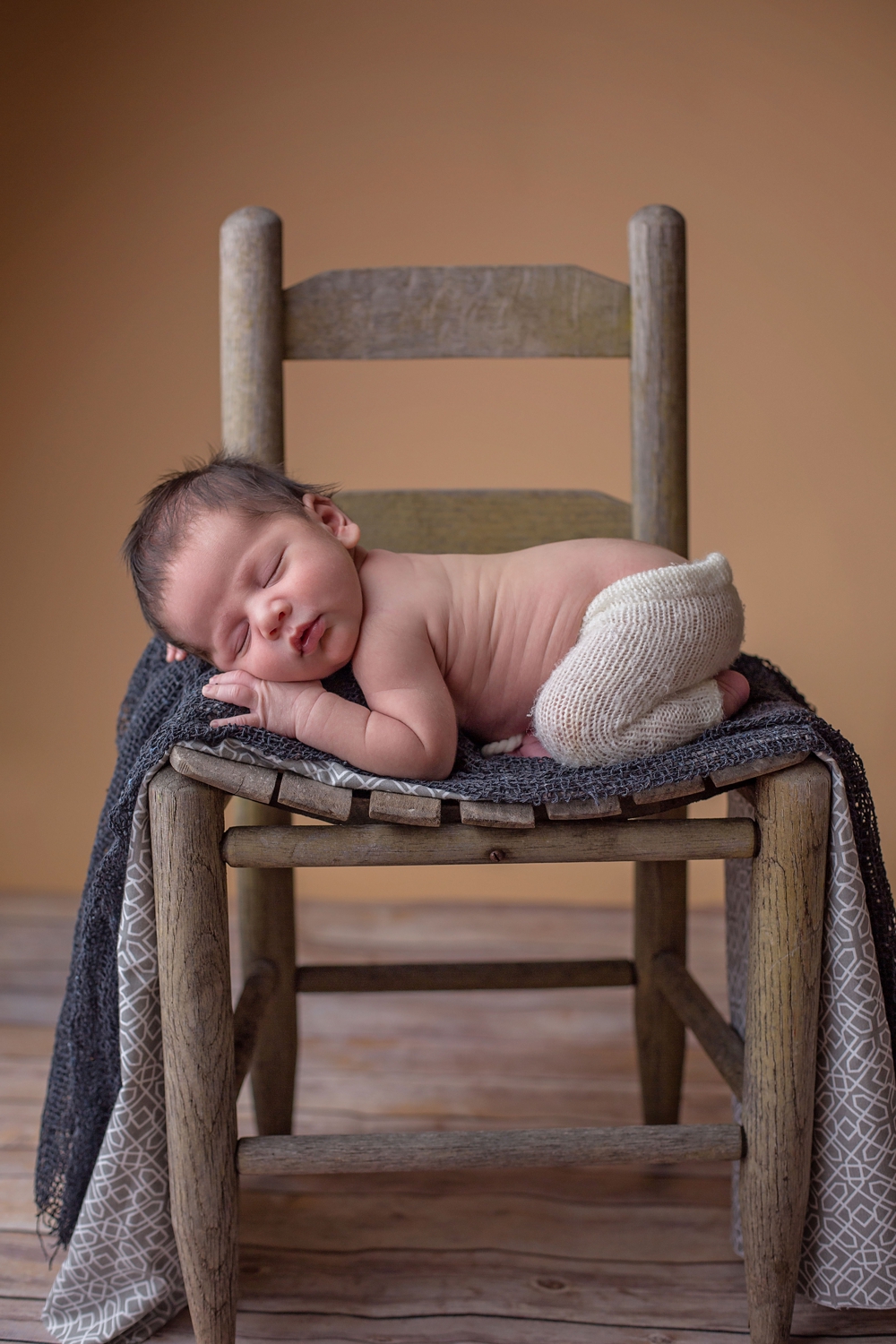 Sweet little boy newborn photo on chair.