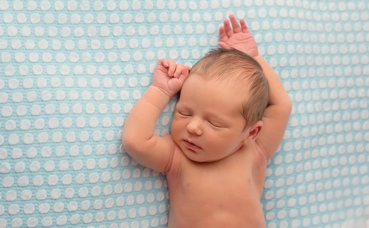 relaxed baby on blue polka fabric