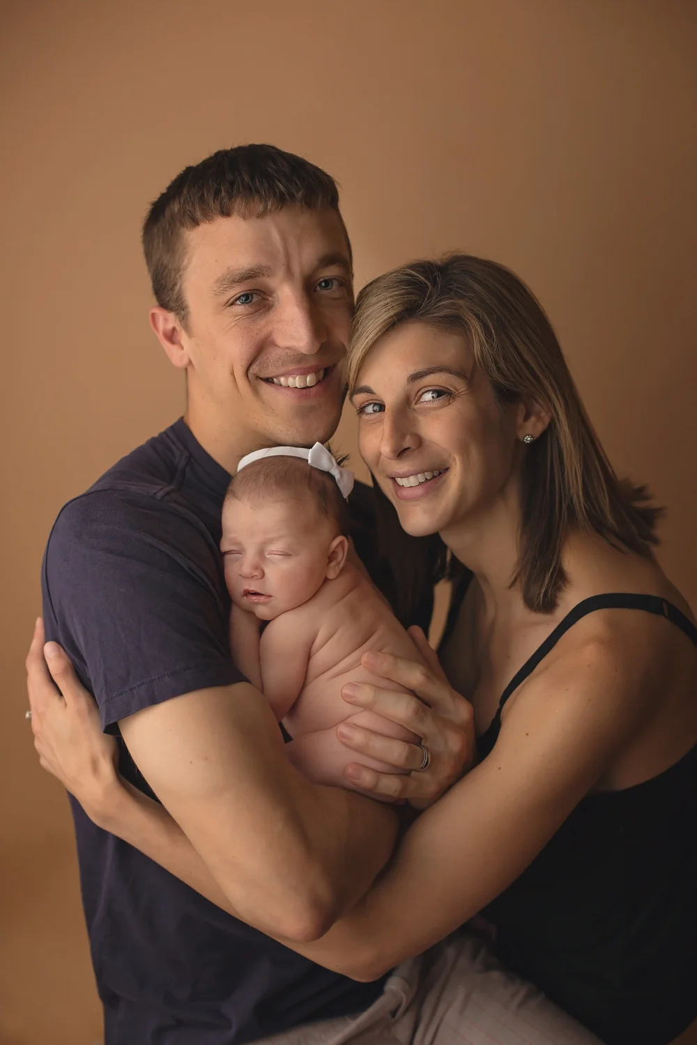 Parents posing for photo with their new baby