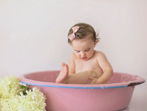 Studio baby girl sits in bath bowl for Pinehurst NC photographer Candace Wolfenbarger.