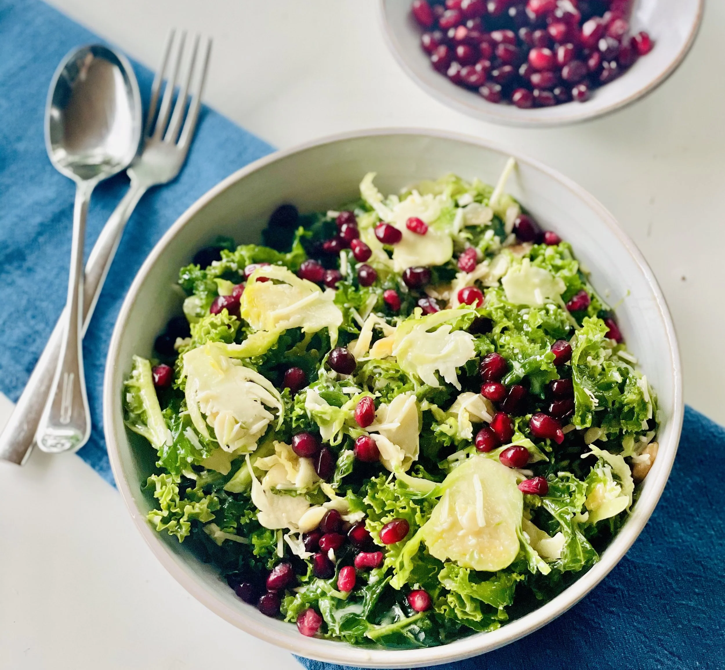 SHAVED BRUSSELS SPROUTS, KALE AND POMEGRANATE SLAW WITH ACV DRESSING