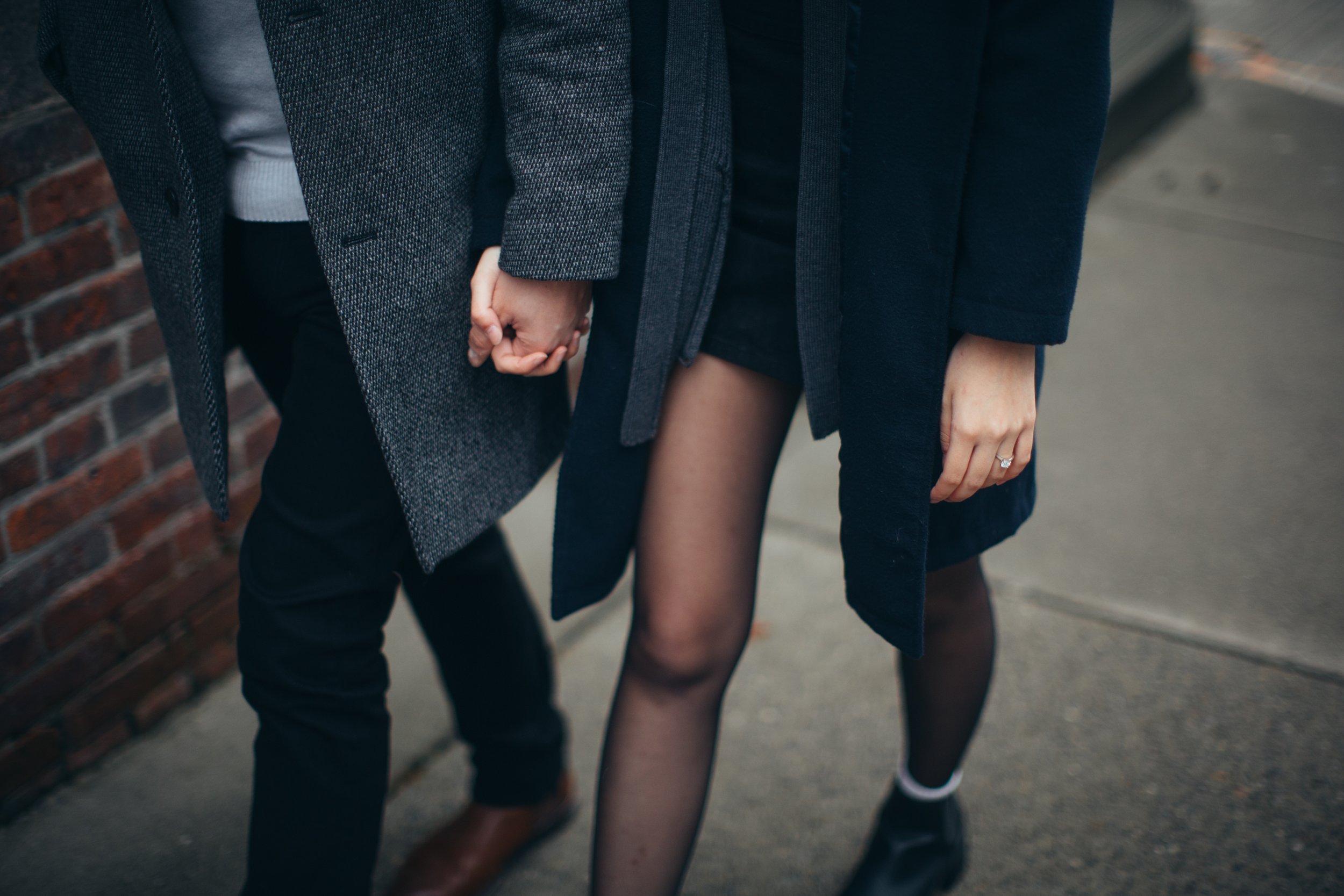 Candid shot of a newly engaged couple holding hands - Photos by Kateland