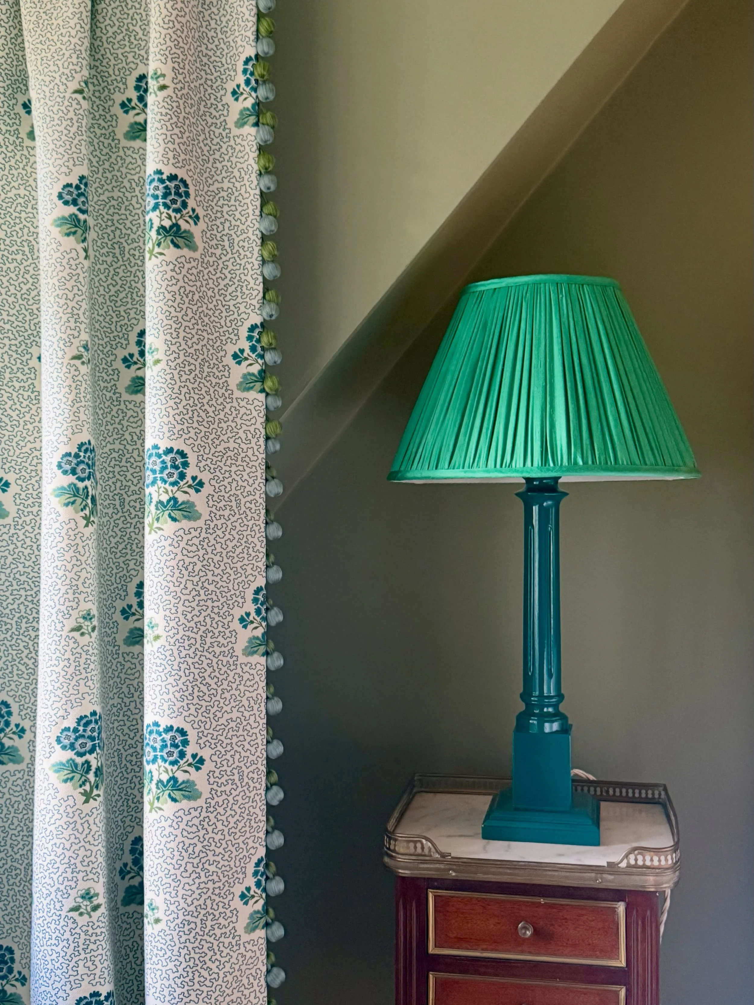 A cosy nook of a recently completed attic bedroom. Beautiful hand sewn curtains for a dormer window using an all time classic &lsquo;Primula&rsquo; by @warnerhouse_1870 trimmed down the leading edges with a tactile bobble trim from @samuelandsons. No