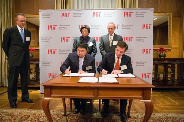 Samuel Tak Lee '62, SM '64 (standing, left) and MIT President L. Rafael Reif look on as Lee's son, Samathur Li, and MIT Executive Vice President and Treasurer Israel Ruiz sign documents related to Lee's $118 million gift to MIT. Image: Bryce Vickmark