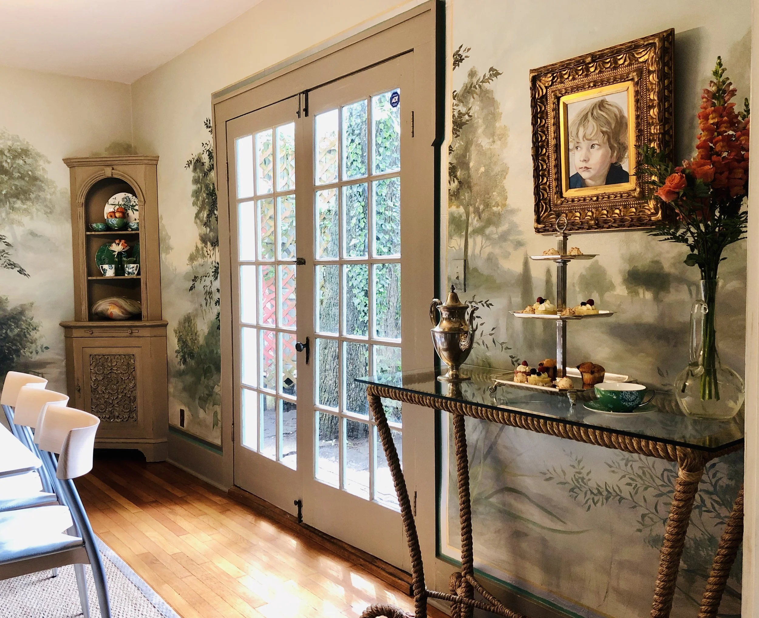 A hand painted mural creates a feeling of immense depth of space in this small dining room.