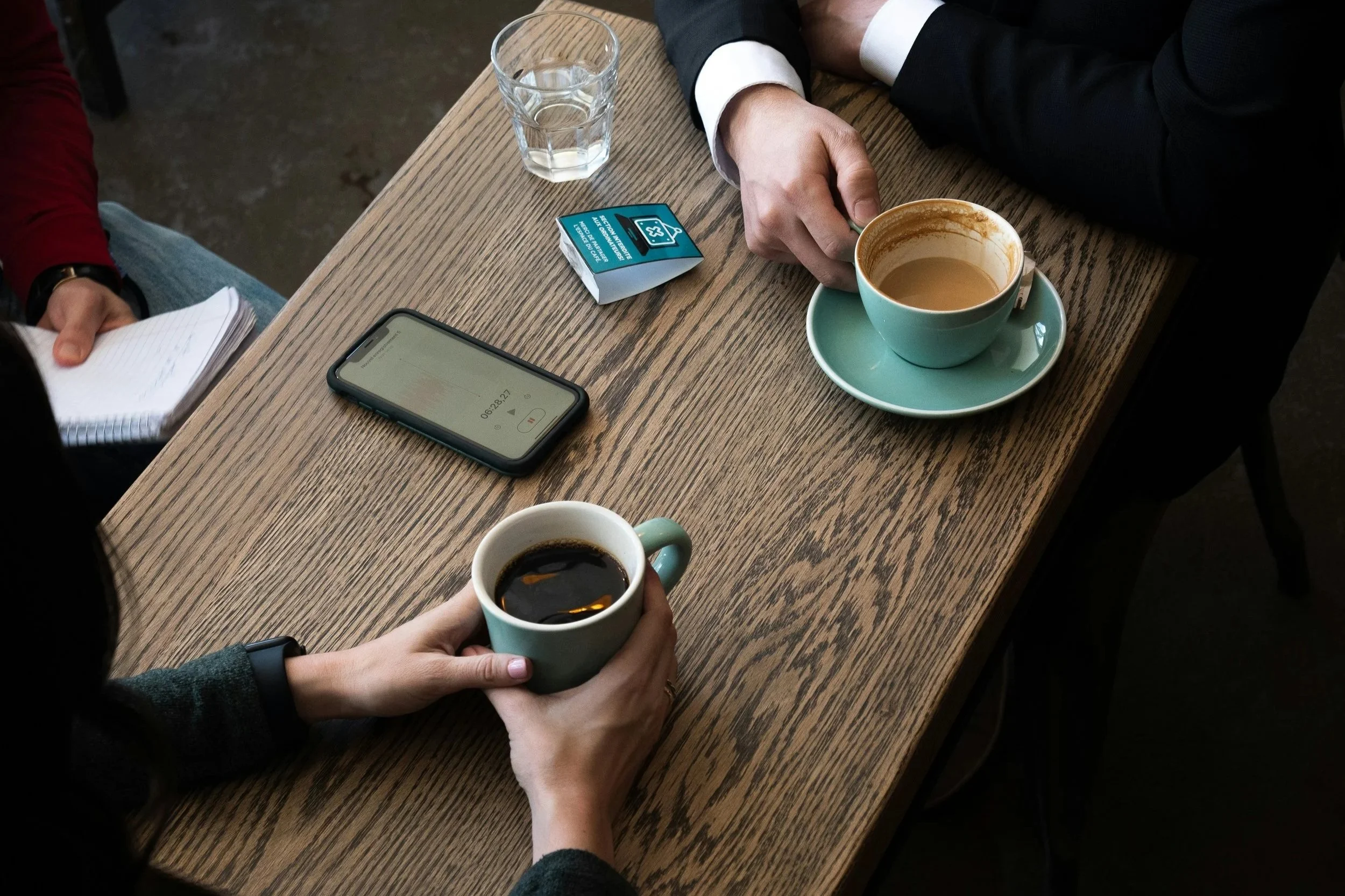 Two people talking over coffee at a cafe table