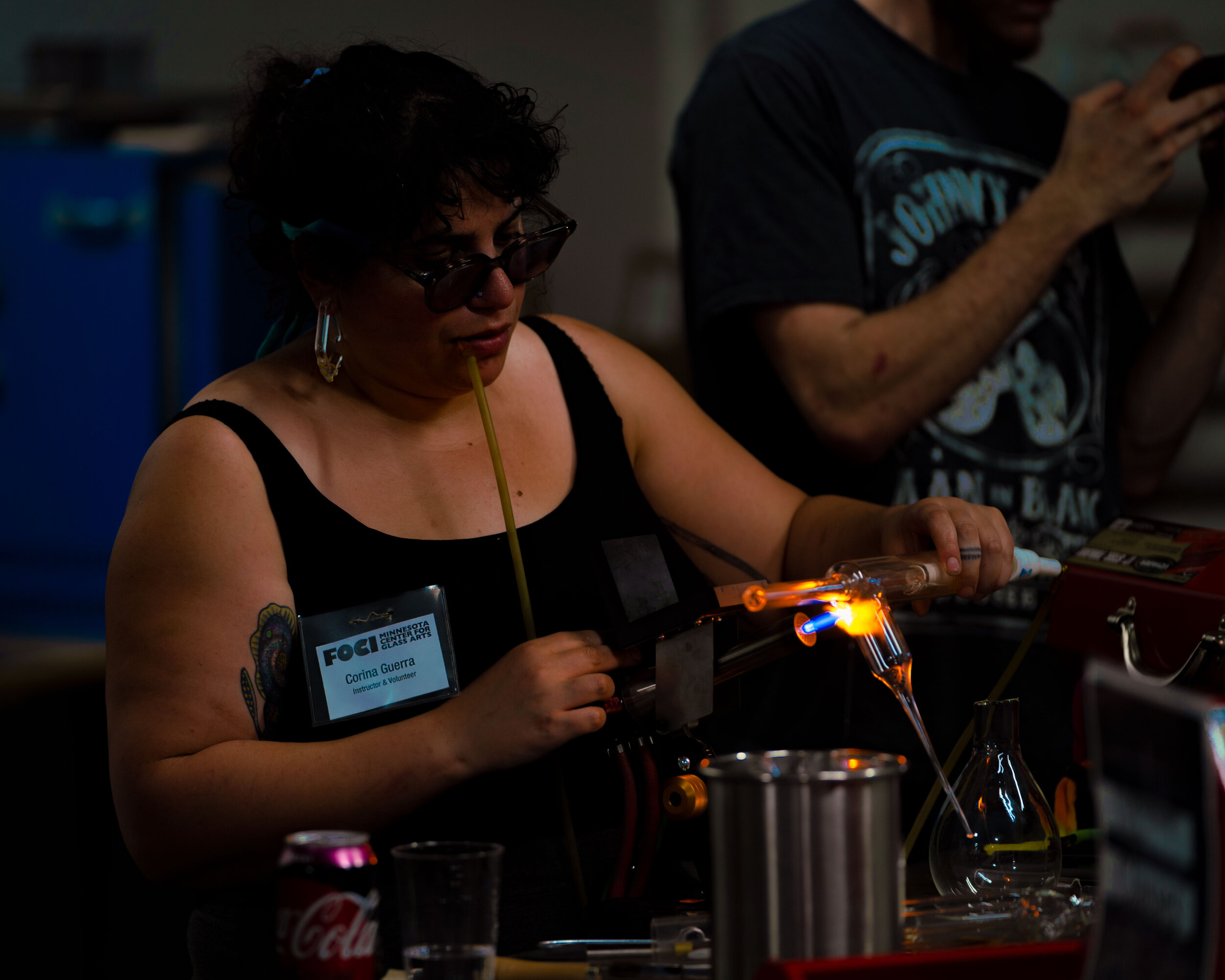  Volunteer and Instructor Corina Guerra working on a flameworking demo. 