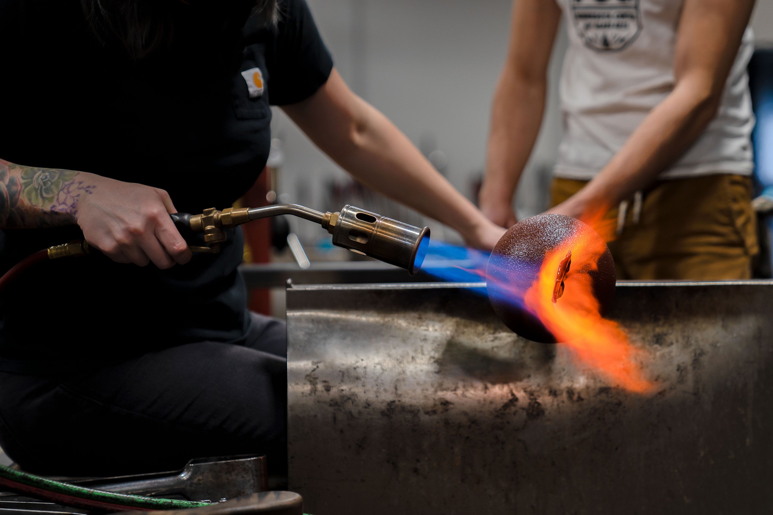 Megan Stelljes reheats a sculpture with a torch during a demonstration for students.