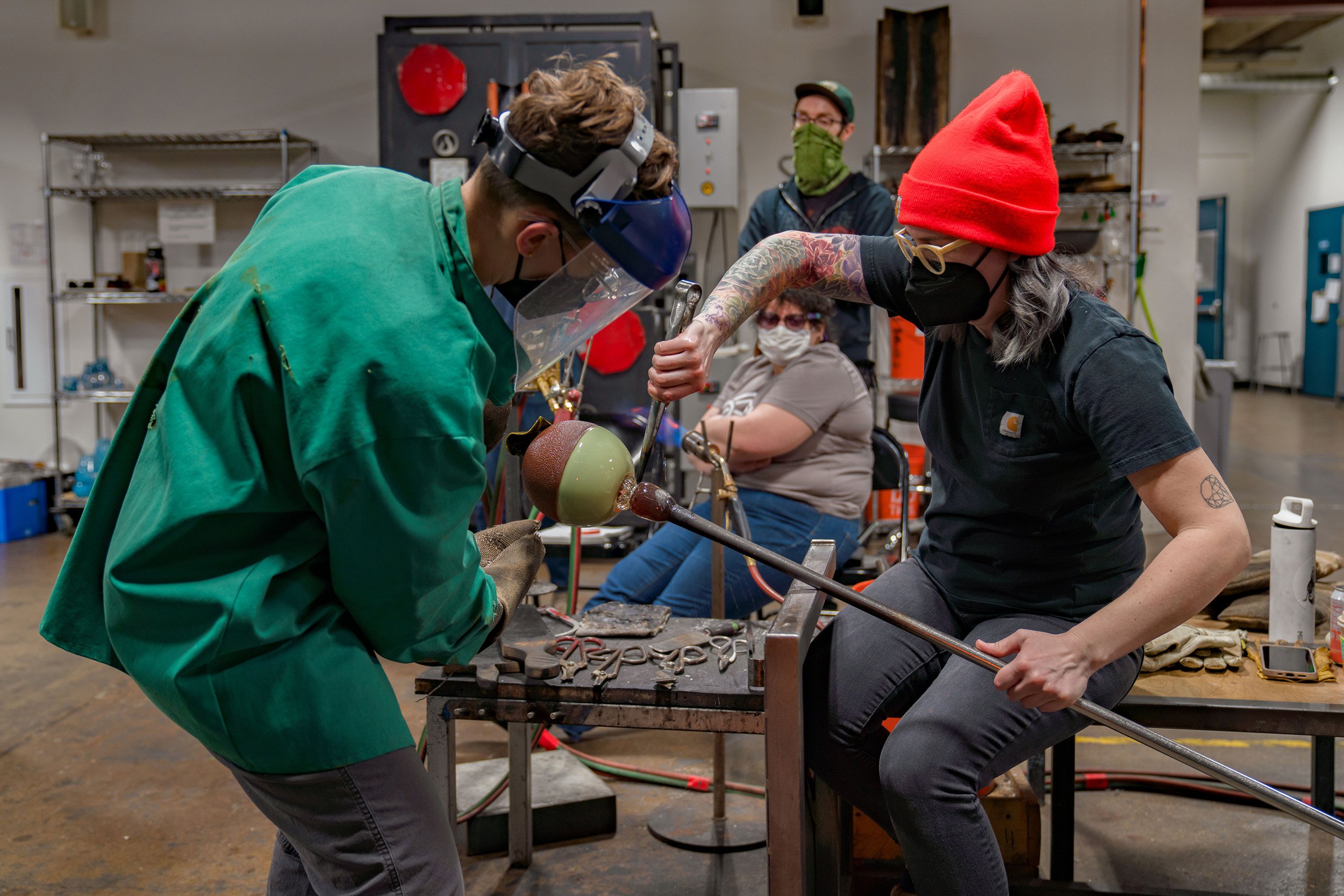 The final steps of creating a glass sculpture - removing it from the punty rod to be annealed!