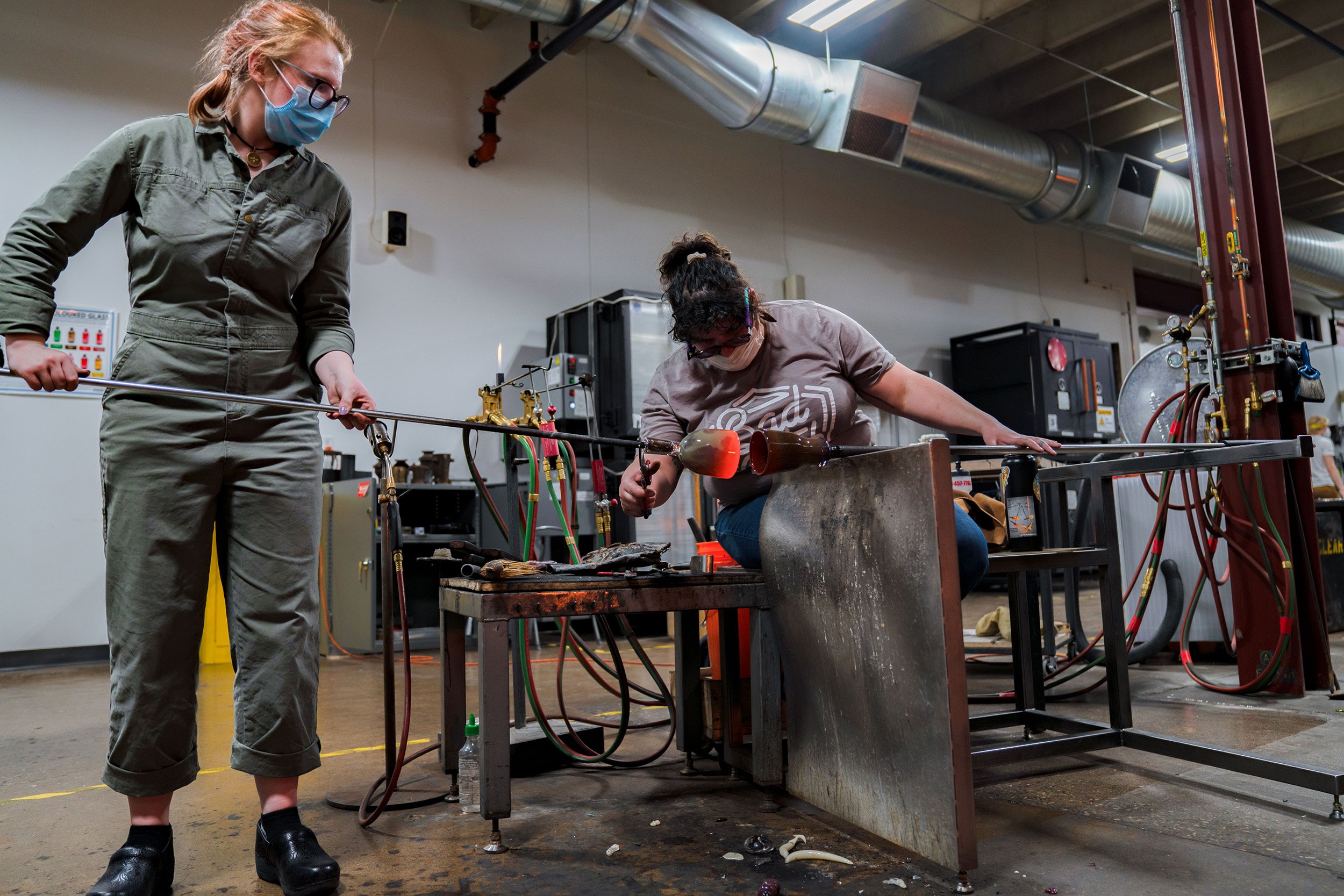 Student Corina Guerra (right) works on a piece with the assistance of Claire Coffee (left) during Megan's class.