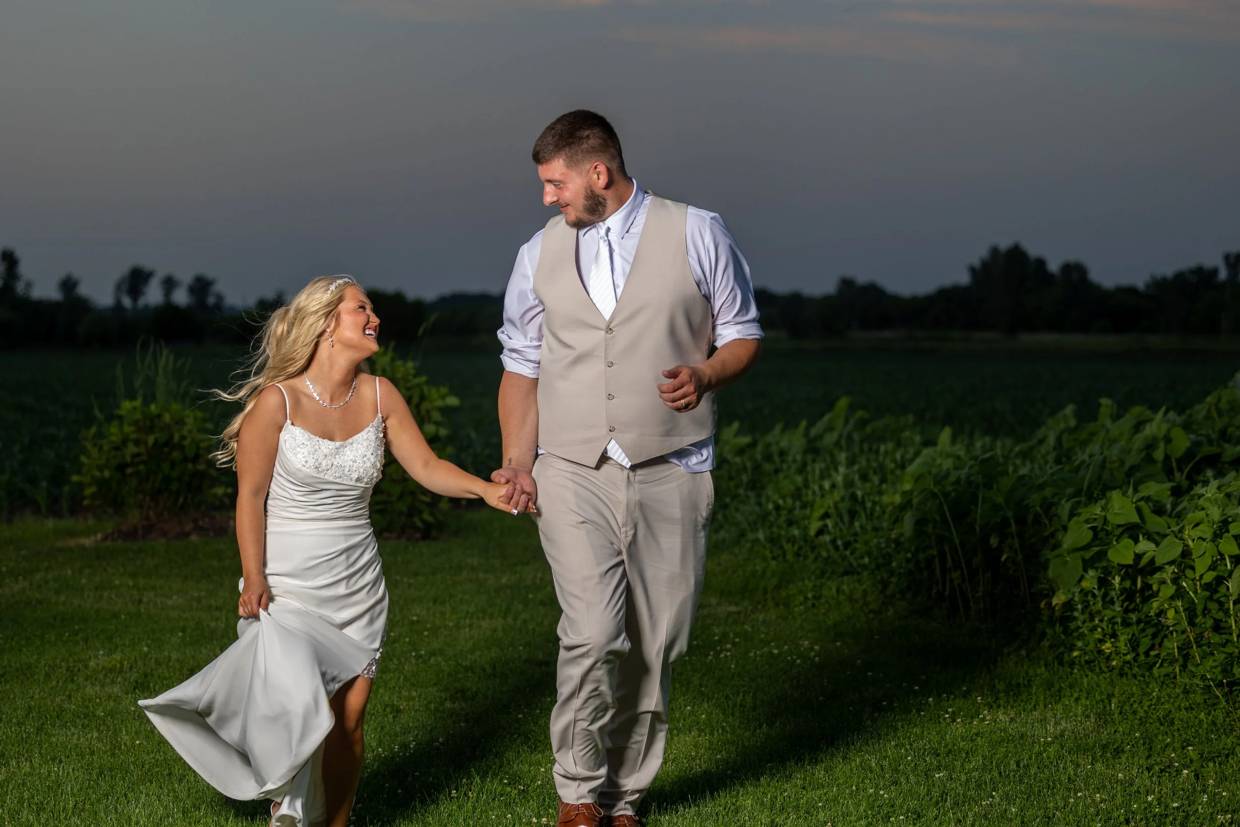 couple holding hands and running on their wedding day