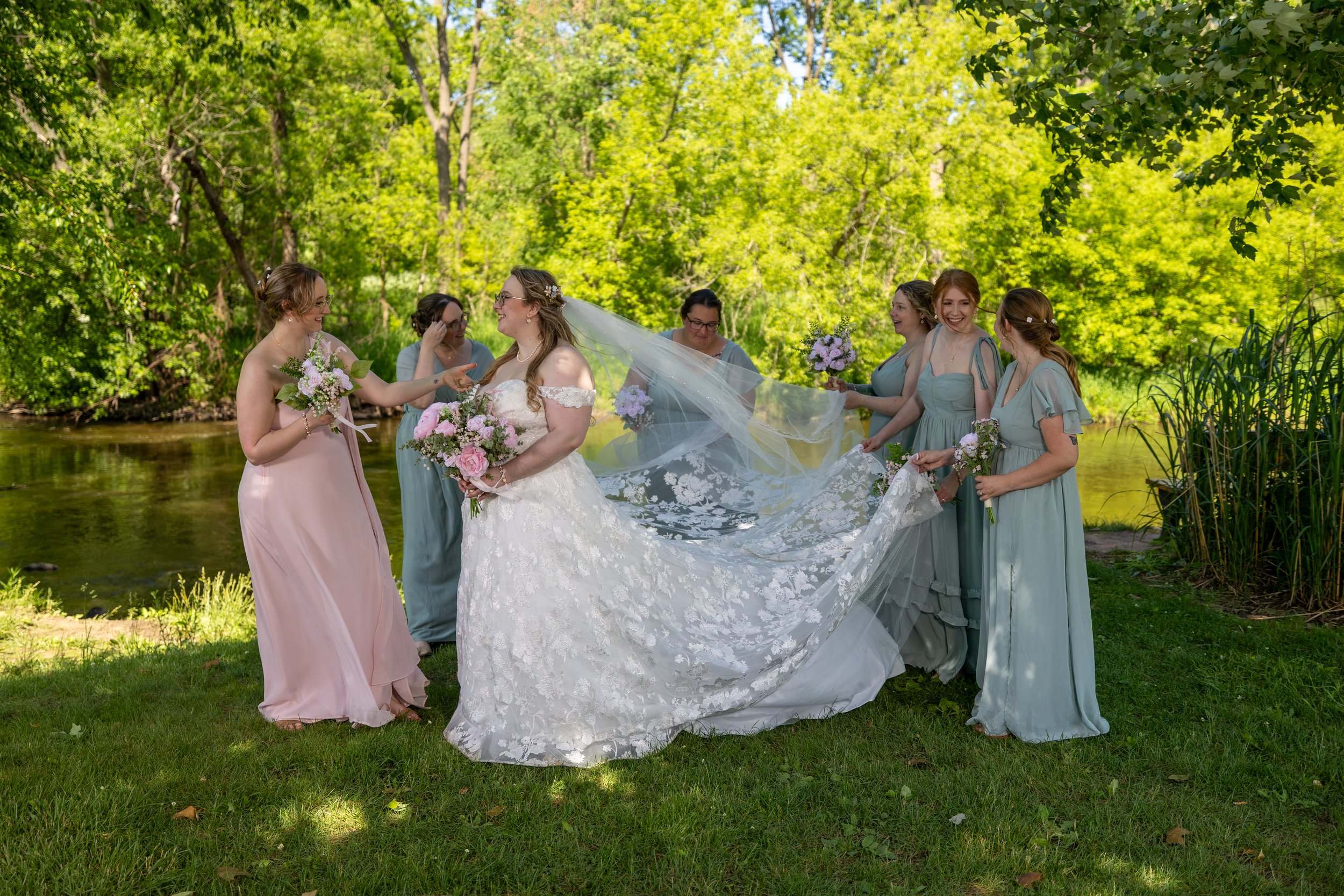 bridal party fixing brides dress