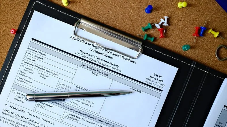 USCIS permanent residence application form with pen on clipboard in San Francisco, CA