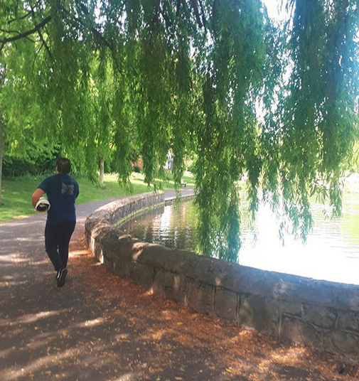 Irish artist Pigsy walks through Ranelagh Gardens Park in Dublin with a rolled up canvas under his arm
