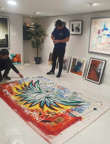 Irish Artist Pigsy unfurls a canvas for stretching in the Frame Shop FrameXperts in Ranelagh, Dublin 