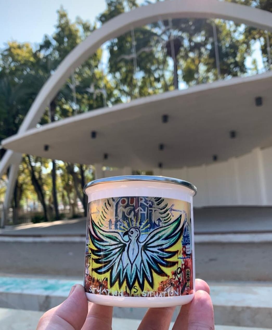 Malaga City Park and Amphitheatre pictured with a "Phoenix Rising" painting cup