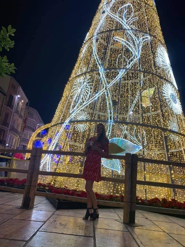 Artist Pigsy took a photo of his wife Enid beside the large Christmas tree on Calle Larios in Malaga in Spain for her sister's facebook album of ladies posing in a party dress