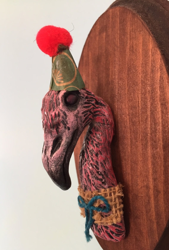 MEMORIES OF FLORIDA Flamingos and sullied beauty.... I sculpted this little flamigo by hand with clay. I use no molds in my process so this guy is one of a kind. He comes ready to party with a little paper hat I made by hand. He's mounted on a wood plaque and ready to hang on your wall.