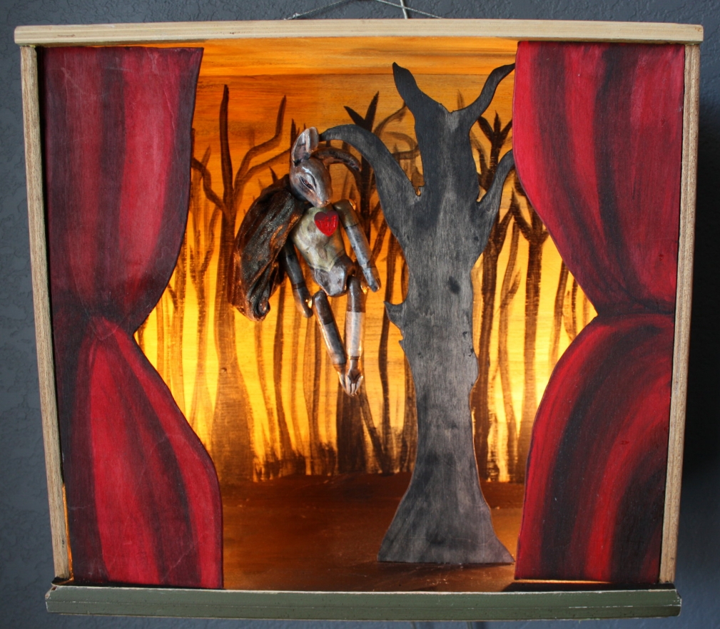 ABSALOM, O ABSALOM Created as part of my "Bunny BIble Show" solor exhibition at Undergrounds Coffeehaus in Ft. Lauderdale, FL. Sculpted from clay, hand painted, hand sewn costume. Set in a salvaged drawer. Diorama elements hand carved and painted. The second son of King David, Absalom, was a prideful and head strong man. “In all Israel there was not a man so highly praised for his handsome appearance as Absalom. From the top of his head to the sole of his foot there was no blemish in him.” Angry with his father King David because of the King's lack of action when his sister is raped, Absalom leads a rebellion against his father. “So the people went out into the field against Israel: and the battle was in the wood of Ephraim...there was there a great slaughter that day, of twenty thousand men...The wood devoured more people that day than the sword devoured.And Absalom met the servants of David. And Absalom rode upon a mule, and the mule went under the thick boughs of a great oak, and his beautiful hair caught hold of the oak, and he was taken up between the heaven and the earth; and the mule that was under him went away leaving him hanging by his hair.And the servants of David took three darts in his hand, and thrust them through the heart of Absalom, while he was yet alive hanging from the oak.” - 2 Samuel 13 and 14