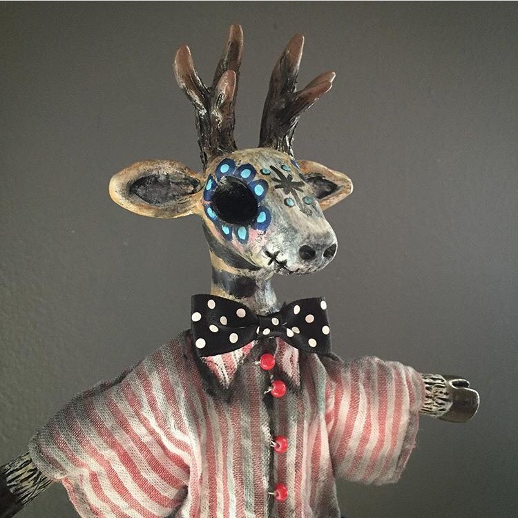 DAY OF THE DEAD DAPPER This Stag was created in the Day of the Dead style. Cone puppets are set inside decorative cones. The puppeteer can pop the puppet in and out of the cone and swirl to make the puppet dance. The head and hands are sculpted with clay. Body made with wire so the arms can move. Costume hand sewn using vintage and new fabric.