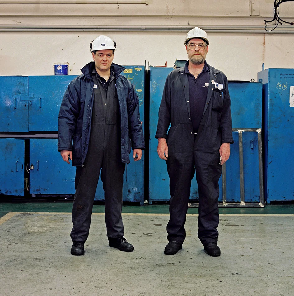 Jason Briggs (left) - Maintenance Fitter - 18 years at the Works Brian Evans (right) - Maintenance Fitter - 34 years at the Works Brian Evans... It was a man’s world where the work could often be hard, but you all worked together for the common good. There was great comradeship and a unique sense of humour and everybody watched each other’s backs in more ways that one. Friendships there were always strong and shared for life. You looked after each other. After all, we were one big family. At the time of closure I felt numb, betrayed and a victim of politics. Numb – Because this was your life and you had not done anything else. You had worked there since school and you had invested your working life into it. Your life was planned around your working there till retirement. Betrayed – Because you had done everything asked of you – the nights in college; training and exams; multiple courses; the unsociable hours to cover all eventualities. Ultimately, your plans had all been destroyed. For a while I had a job with a contract firm who were dismantling the Works. It was surreal taking apart plant that I had been looking after all my life. Now I was dismantling it and putting it onto the backs of lorries to be sent all over the world and never seen again. I felt like I was desecrating a grave. Since the day the Works closed up to now, there have been loads of people (literally hundreds) that I have not seen again, although I knew them all my working life. They all live in different towns and our paths never normally cross. Sometimes you hear of someone passing away and all the memories keep flooding back. I guess all the people who worked there are still grieving in their own way.