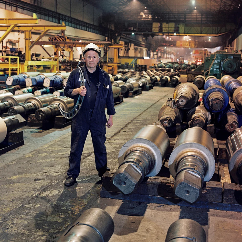 Philip Lawton - Fitter/Roll Grinder - 34 years at the Works At the start of my apprenticeship in 1968, there were approximately 10,000 people working at the Richard, Thomas and Baldwins (RTB) Steel Works in Ebbw Vale. The Apprentice School was situated at the South end of the works, in Victoria, and the enormous size of the Steel Plant was locked into my memory when in my first year of employment I had to walk to work through the snow. Walking through the various Mills and Departments along the length of the works was the easiest and quickest option. The sounds and sights I experienced on that trek left a lasting impression on someone who had only just left school. The constant noise from the Tinplate Lines, the smell of the acid being used to clean the steel coils in the Pickler, the sight of a large hot steel ingot as bright as the sun, being reduced to a thin steel slab, together with the bright light emanating from the Converter Shop lingers in the mind. Standing out amongst my memories of the Plant, are the characters that enlivened the working day. From the workmate who often performed his version of the floral dance, wearing steel clogs, on an empty oil drum, to the workmate who used paraffin to show his prowess as a fire breather. Unfortunately he set fire to the hair of a fitter working near him and spent the rest of the shift, playing hide and seek with the gentleman who had a smoking head. The closure impacted on everyone. No matter what age group you were in, you had concerns, not only for your own future but also that of the people you had been working alongside for the best part of your life. The younger element had mortgages and family to worry about. The older workers had the worry of their pension options/prospects to be added to the list of the unknown problems that would face everyone with the sudden loss of earnings and probable long-term unemployment. Many of those working at Ebbw Vale had to suffer the upheaval of moving home and family to the Swansea area. Others have constantly commuted between Ebbw Vale and Port Talbot on a daily basis. The closure of Ebbw Vale Works obviously had a detrimental effect not only on the majority of those who had worked at the plant, but also on the future job prospects of the younger people in the area.