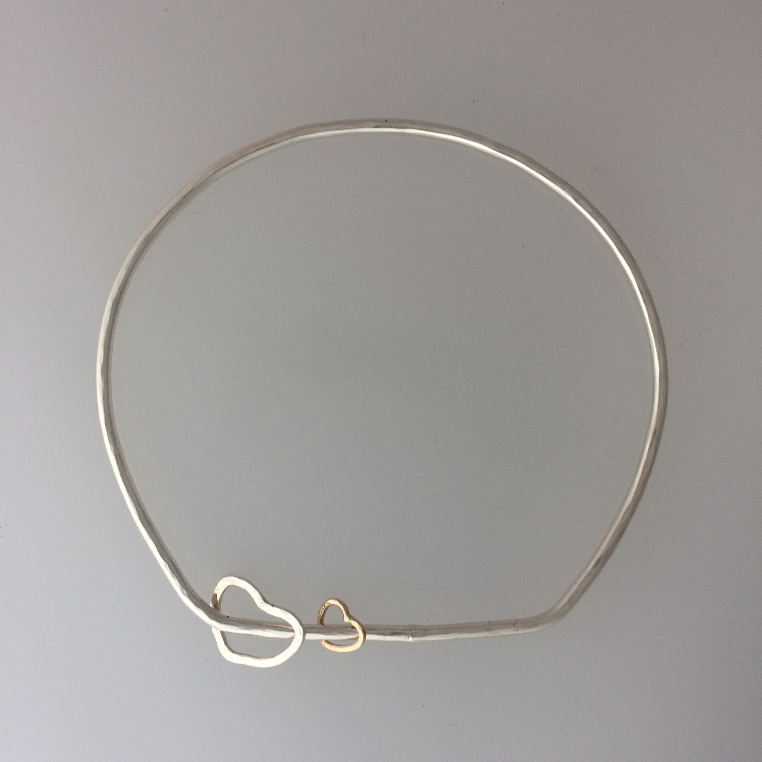 Silver bangle with heart-shaped spinners