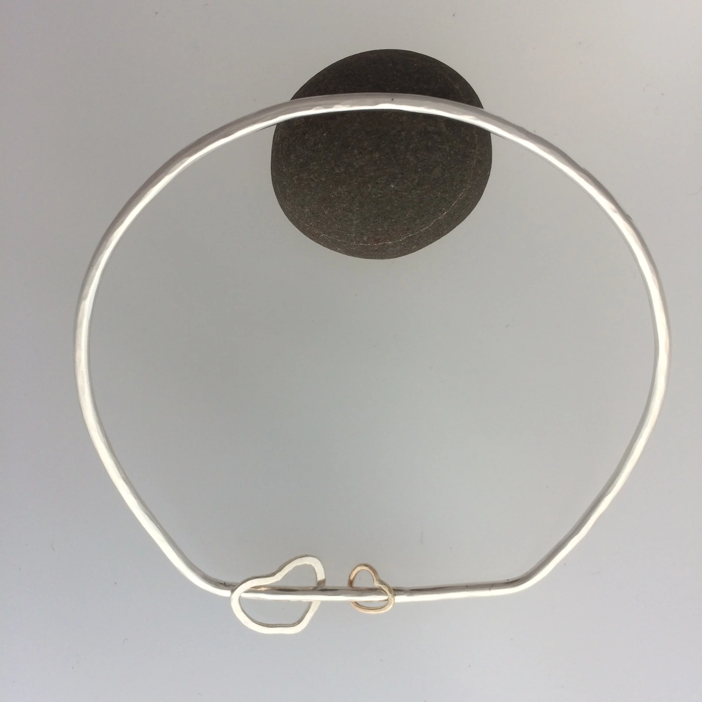 Silver bangle with heart-shaped spinners
