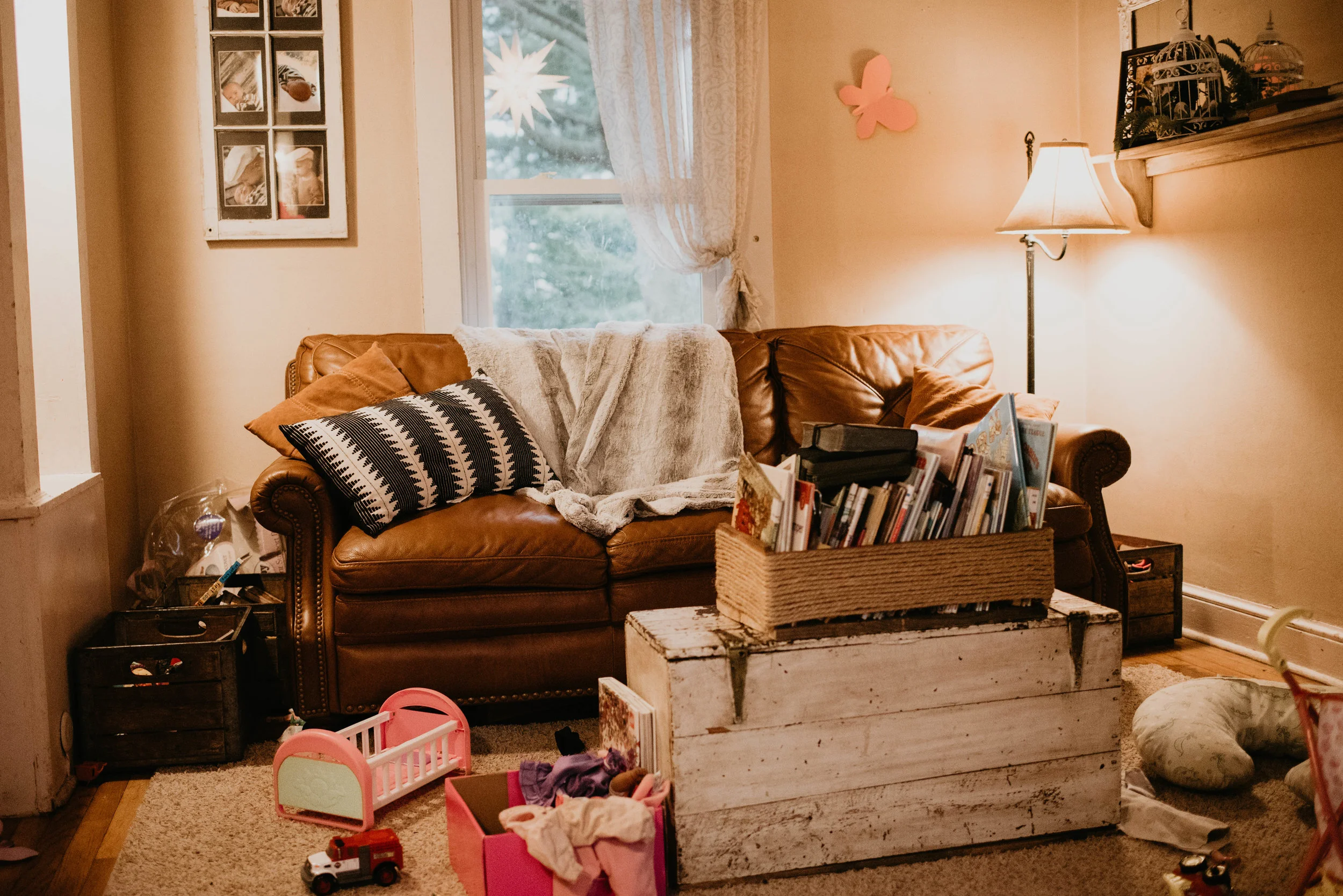 Again here is a photo of my small messy living room. I recently took the photos below in this same room of my home of a client's 6 month baby. To clear the clutter, and make the baby our main focus, a lot of this room was moved into the room next to it. The toys were clean up off the floor. The boxes on either end of the couch, the trunk with books, and even the window photo frame on the wall, all were moved out. A house doesn't have to look like pintrest. The focus isn't the home but rather the interaction of baby and family. The emotion is what makes these lifestyle photos beautiful!