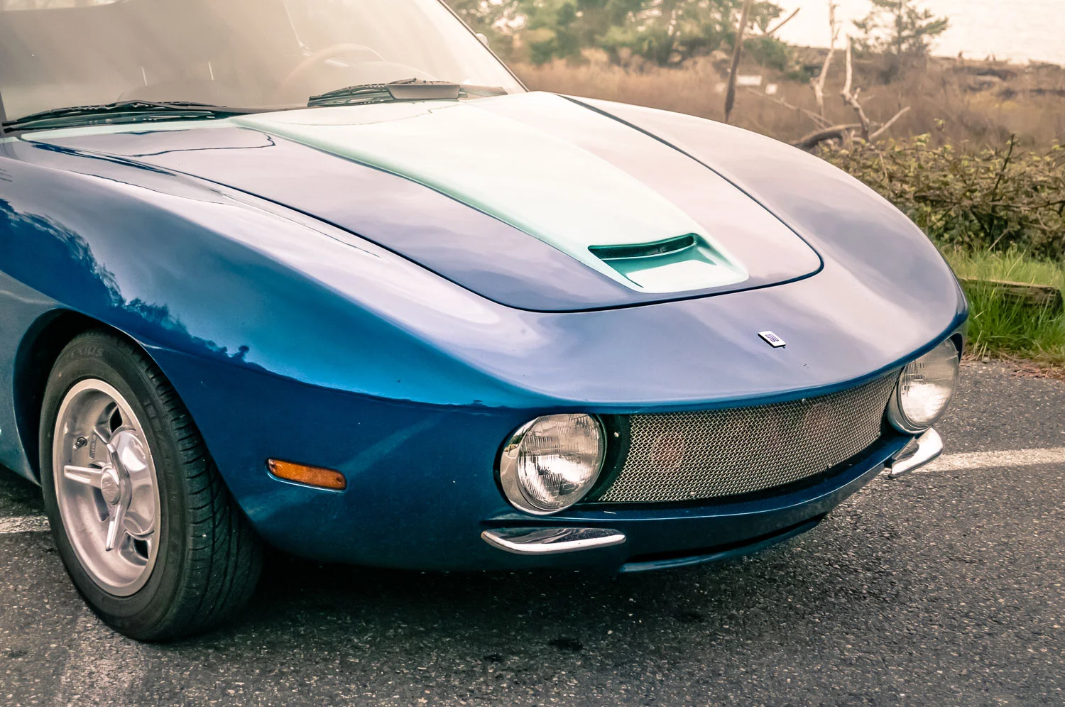 The front fender sweeps are inspired by the Iso Grifo, with other styling cues putting a modern spin on Michelotti. The hood scoop evokes Jim's previous work with Blue Ray 3. The base platform and mechanicals come from a 1st generation NA Miata, cut and heavily modified to create the Manta Ray. Only 2 Manta Rays were ever produced—one in Nassaw Blue. The original Manta Ray, still owned by Jim, was initially painted Ferrari Modena 360 yellow and later repainted and detailed in the exact colours of the Nardi Blue Rays. Paint was contributed by PPG Paints .